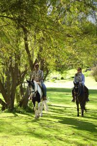 乌鲁班巴Rio Sagrado, A Belmond Hotel, Sacred Valley的公园里骑马的男人和女人