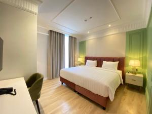 雅加达Maia Hotel Jakarta的配有一张床和一张书桌的酒店客房