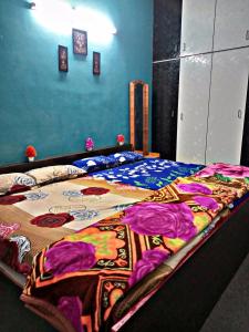 甘吉布勒姆Sai Homestay的床上有五颜六色的毯子