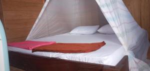 BesirArborek Diving Homestay R4的一张带白色床单和红色毯子的床