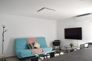 GuineaCasa Sabare的客厅配有蓝色的沙发和平面电视。