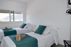 GuineaCasa Sabare的白色的客房设有两张床和窗户。