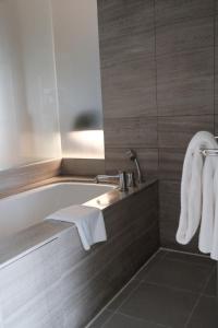 新德里新德里国际机场假日旅馆的带浴缸和盥洗盆的浴室