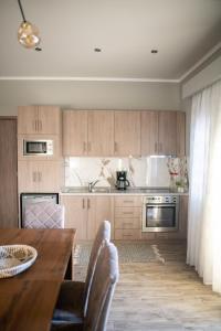 阿吉奥斯阿姆罗斯奥斯HOMER的厨房配有木制橱柜和桌椅
