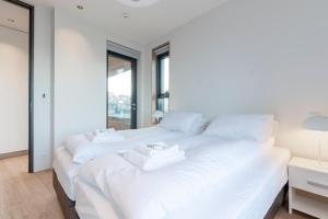 雷克雅未克Blue Viking Apartments Reykjavik的一间白色卧室,床上配有2条白色毛巾