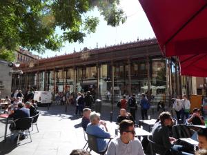 马德里Apartamento en el Mercado de San Miguel的一群坐在大楼前桌旁的人