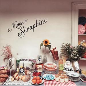 拉昂Maison Séraphine - Guest house - Bed and Breakfast的一张桌子,上面有食物和读过传说的标志