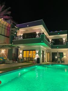 Ash ShāghūrVilla Jana chalet - Private Villa - Dead Sea - Jordan的一座大型游泳池,在晚上在房子前面