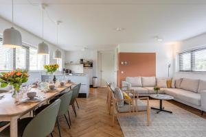 诺德韦克Duyndomein Noordwijk的用餐室以及带桌子和沙发的客厅。