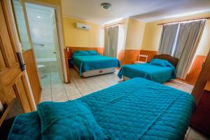 卡尔德拉Hotel Montecarlo的酒店客房带两张床和一间浴室