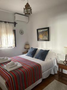 格拉纳达拉卡斯塔德尔喀拉隆旅馆的一间卧室配有一张大床和色彩缤纷的毯子