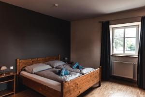 Heinerscheid考恩里沙夫酒店的一间卧室配有一张带蓝色枕头的床和一扇窗户。