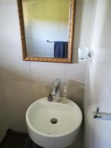 戈登湾Crossroads Guestrooms的浴室设有白色水槽和镜子