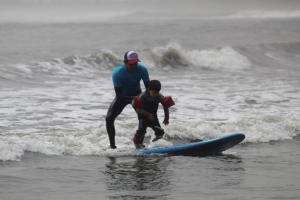 万查科Totora Surf Hostel的海面冲浪板上的男人和孩子
