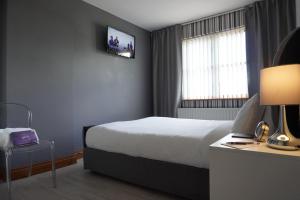 波塔当VIP@TheMeadows的酒店客房设有一张床和墙上的电视
