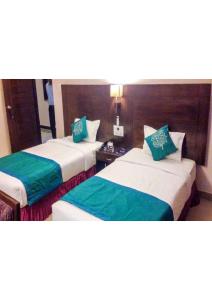 菩提伽耶Shining star的配有绿色枕头的酒店客房内的两张床