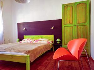 鲍洛通费尼韦什Apartment for 5 ppl at Lake Balaton的一间卧室配有一张床和一张红色椅子