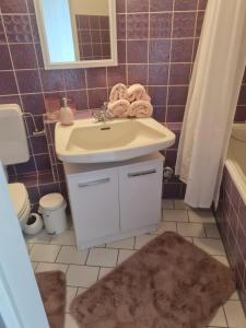 石勒苏益格Ferienwohnung NABOO的浴室配有盥洗盆、卫生间和浴缸。