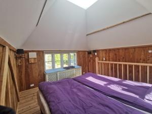 FaxeBirkevang The Silo - Rural refuge的一间卧室设有紫色的床和窗户