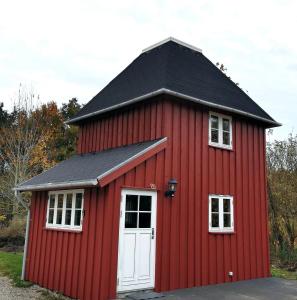 FaxeBirkevang The Silo - Rural refuge的黑色屋顶和白色门的红色谷仓