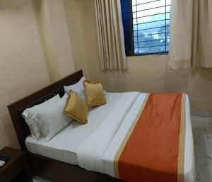 纳威孟买Hotel Royal Residency的卧室配有带枕头的床铺和窗户。