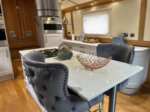 阿克斯桥Luxury boat - The Thistle Dream的厨房配有带2把椅子的桌子和炉灶。