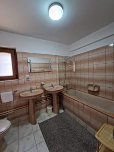 瓦马Pensiunea Irina的浴室配有2个盥洗盆和1个浴缸。