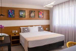 AndradasPorto das Asas Park Hotel的一间卧室配有一张大床和一张桌子
