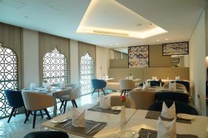 多哈C - Hotel and Suites Doha的用餐室设有桌椅和窗户。