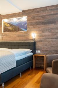 达沃斯岳罗普酒店的一间卧室设有一张床和木墙