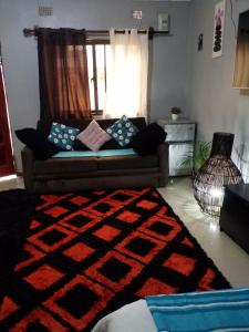 卢萨卡Keresia's guestwing的带沙发和地毯的客厅