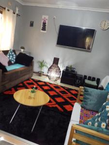 卢萨卡Keresia's guestwing的客厅配有沙发和桌子