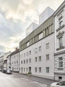林茨HÜBSCHES APARTMENT im Herzen von Linz的一条城市街道上的白色大建筑