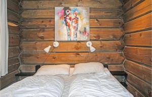 斯朱森3 Bedroom Cozy Home In Sjusjen的卧室配有木墙内的一张床