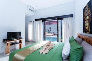 塞米亚克Villa Joylen Seminyak Bali的一间卧室配有一张床,床上有毛巾