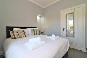 格拉斯哥Signature - Greenlees Clubhouse的卧室配有带毛巾的大型白色床