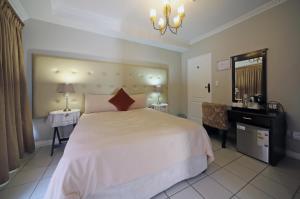 开普敦萨伏依酒店的卧室配有一张白色大床和一张书桌