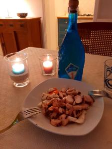 卡普里Cataldo Guest House的桌上的盘子,带一瓶和蜡烛