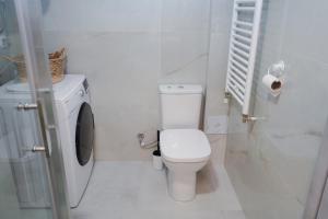 斯科普里Sunlight Apartment的白色的浴室设有卫生间和洗衣机。