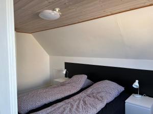 哈博尔Hyggeligt byhus的卧室内的两张床,配有黑色床头板