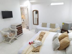 卡塔赫纳Casa Ego的白色的客房配有床和电视。