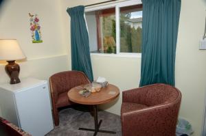 阿伯茨福德Guest Suite Private Retreat- Honeymoon Suite- J-1的一间设有两把椅子、一张桌子和一个窗户的房间
