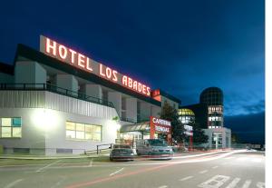 洛哈Hotel Abades Loja的一家晚上在街上停车的酒店