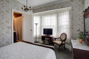 五月岬郡威尔布拉汉姆大厦酒店的一间卧室配有一张床、一台电视和一把椅子