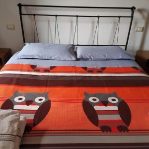 卡斯特姆苏La Chiusa dei Monaci的橙色和黑色的床,配有猫头鹰被子