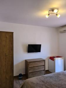 曼加利亚Casa Anne的一间卧室配有一张床,墙上配有电视
