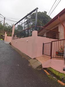 San MarcosCasa entre la naturaleza的一座带粉红色墙壁和阳台的房子