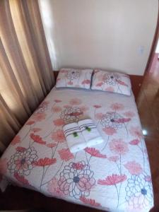 San MarcosCasa entre la naturaleza的一张带花卉床罩的床和两个枕头