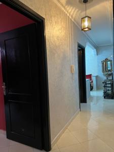 丹吉尔Appartement Tanger的走廊的房间里,有一道黑色的门