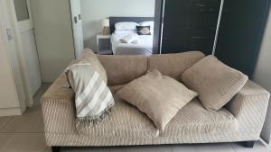 穆卢拉巴Mooloolaba Beach Beachwalk的卧室内的沙发上配有枕头